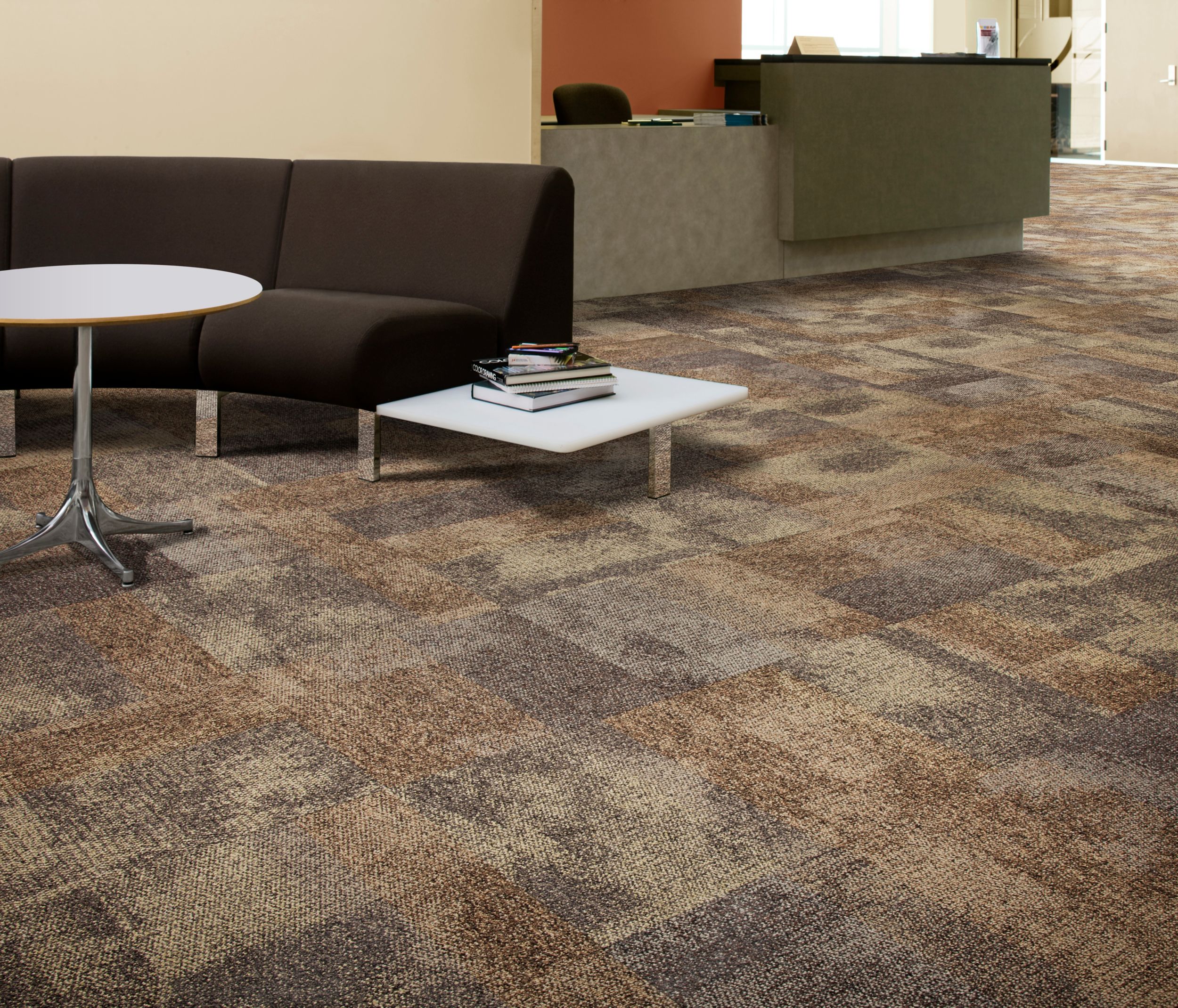 Interface Exposed carpet tile in front desk waiting area with books and notepad on table and black couch image number 10